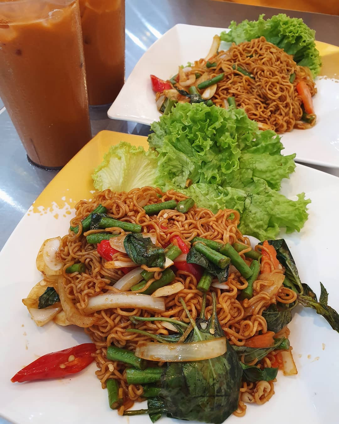 Phad ki mao mama with seafood ($6 each) & Iced Thai milk tea ($3 each) — Burpple Beyond: $9!