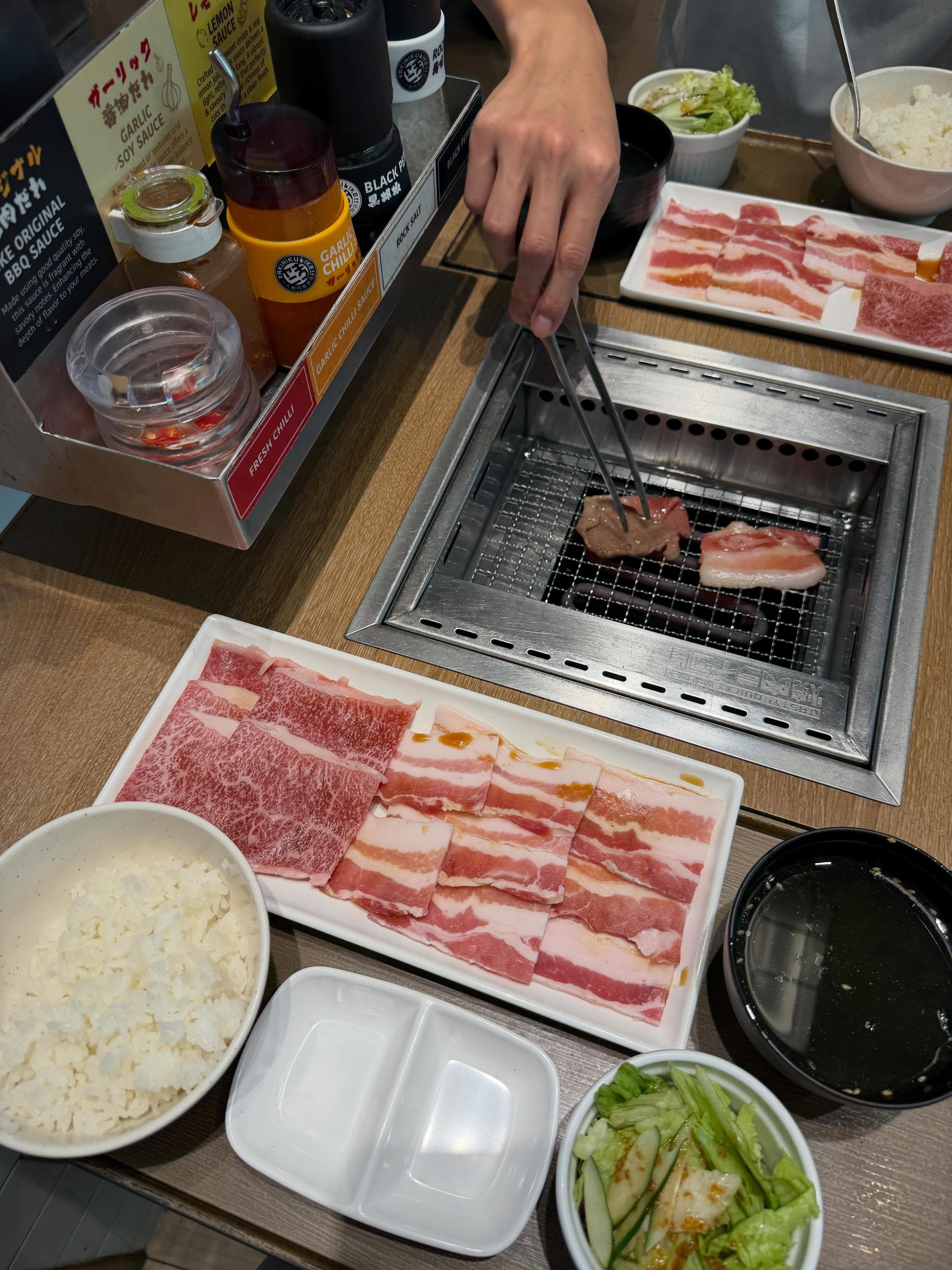 Raw wagyu and pork belly slices on the personal tabletop grill at Yakiniku LIKE